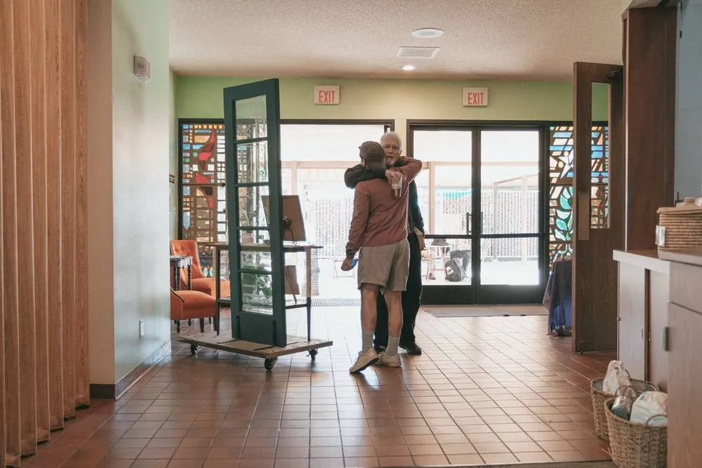 Two people greeting one another in the doorway of the church.